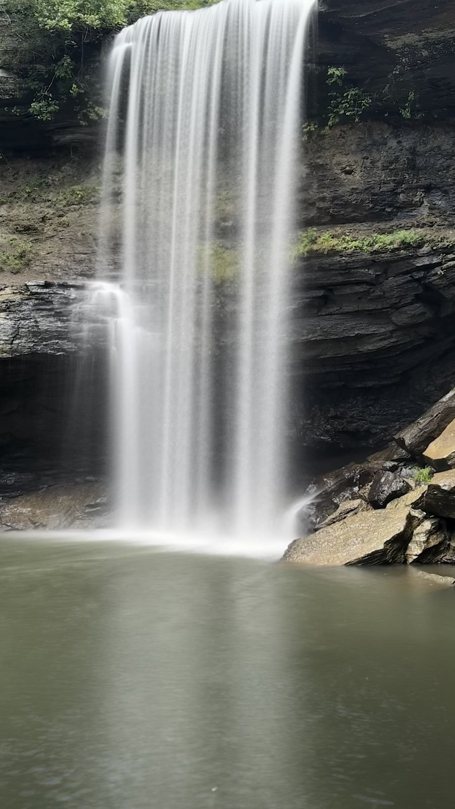 Long-exposure photo of Lower Greeter Falls in Tennessee, the water blurred into a smooth curtain